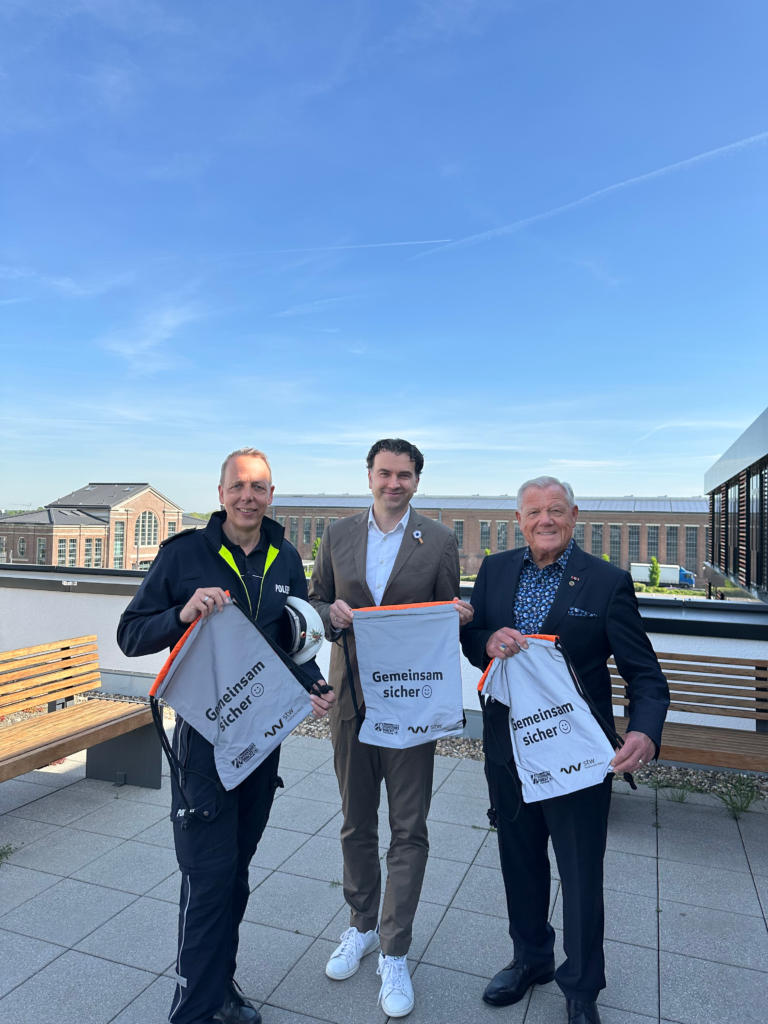 Vertreter der Stadtwerke Willich und der Kreisverkehrswacht Viersen mit reflektierenden Sportbeuteln für mehr Sicherheit auf dem Schulweg