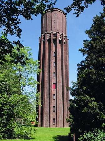 Wasserturm Fellerhöfe in Willich – Ziegelturm zwischen Bäumen bei blauem Himmel