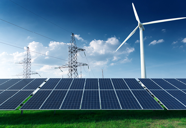 Solarmodule, Windrad und Strommasten auf einem Feld – Symbolbild für die Strominfrastruktur, für die Netzentgelte erhoben werden