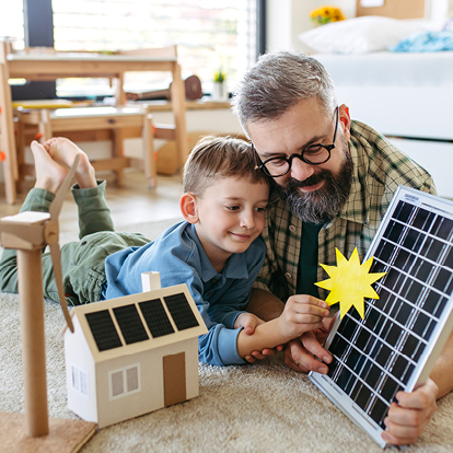 Vater und Sohn entdecken gemeinsam die Möglichkeiten von Sonnenenergie – Symbolbild für Ökostrom der Stadtwerke Willich