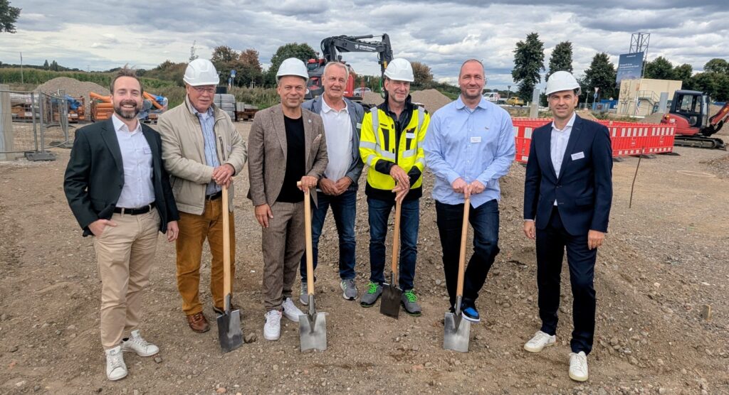 Gruppenbild mit sieben Beteiligten des Spatenstichs vor dem neuen Ladepark Münchheide V