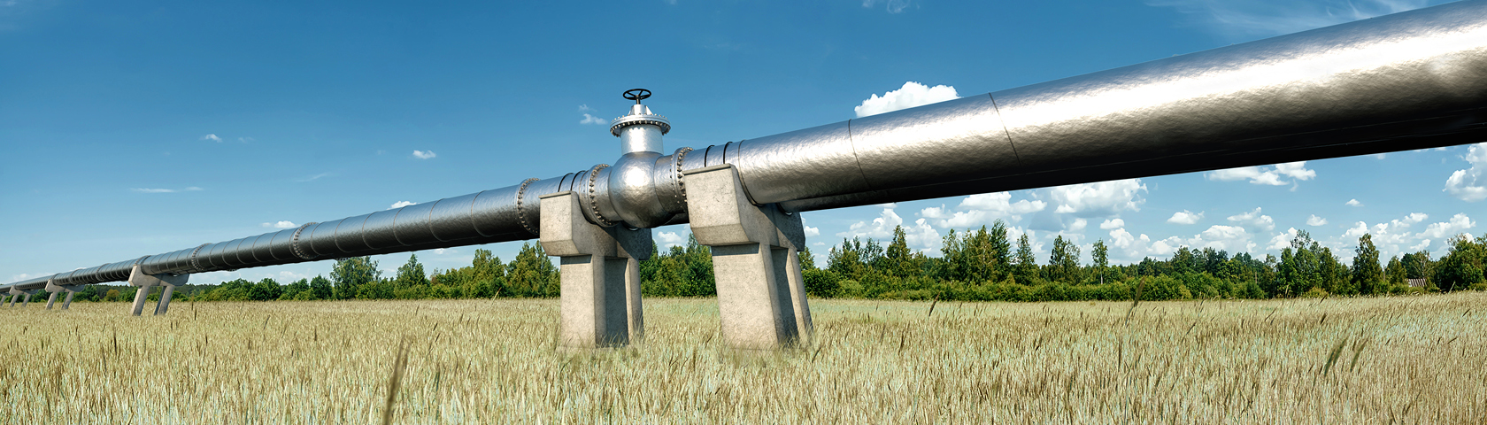 Silberne Gasleitung verläuft über eine Wiese unter blauem Himmel