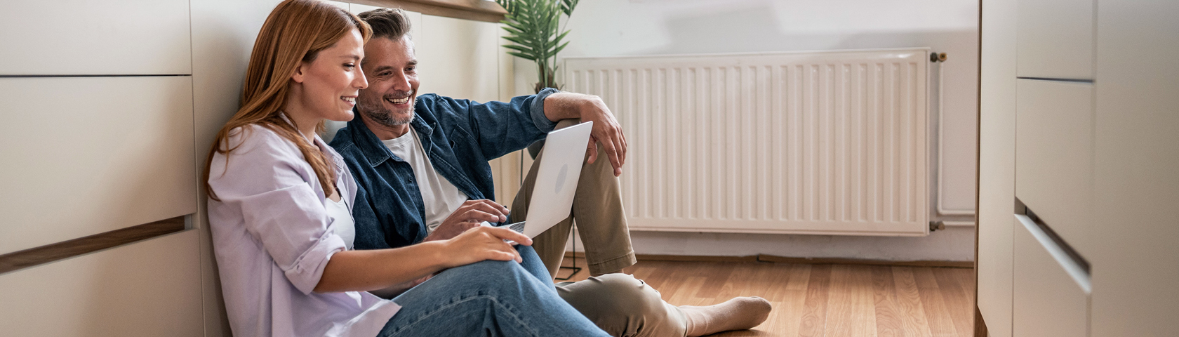 Familie sitzt entspannt vor der Heizung und genießt angenehme Wärme im Wohnzimmer