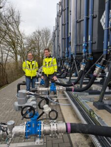 Daniel Wolter und Lutz Meierherm stehen vor Aktivkohle-Filtrationsanlage im Wasserwerk