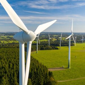 Mehrere Windkraftanlagen zwischen Feldern und Waldflächen