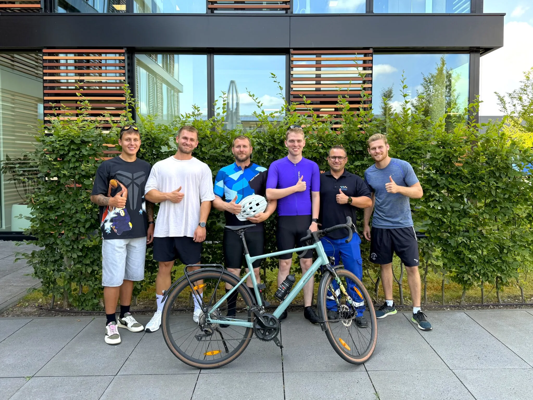 Sechs Mitarbeitende der Stadtwerke Willich mit Fahrrad und Fußball
